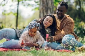 toddler and parents playing with bubbles outside