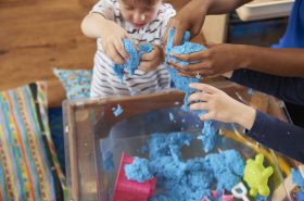 Child playing with squishy recipes in sensory bin at daycare