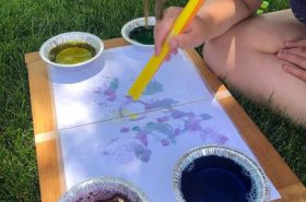 School-ager making a bubble art painting outside