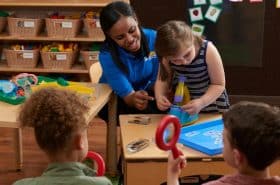 Teacher helping child look through microscope for a STEAM activity