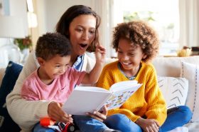 Mother reading a book with her two children on World Book Day