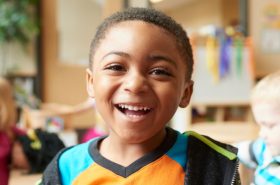 preschool boy smiling on his first day of childcare at New Horizon Academy