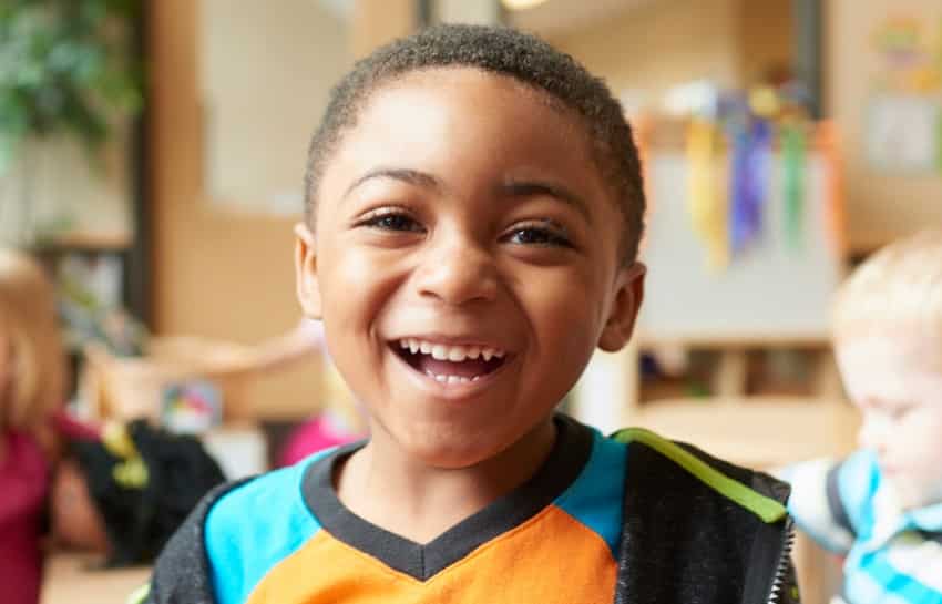 preschool boy smiling on his first day of childcare at New Horizon Academy