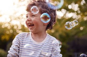 Young boy playing with scented rainbow bubbles