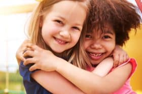 two preschool girls hugging