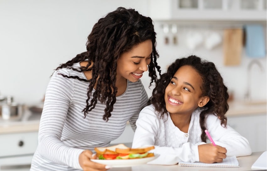 mother giving daughter an after school snack