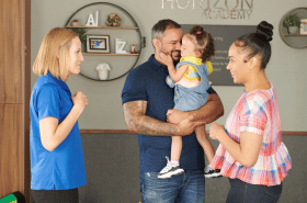 happy parents talking with daycare teacher