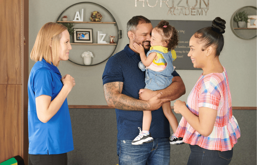 happy parents talking with daycare teacher