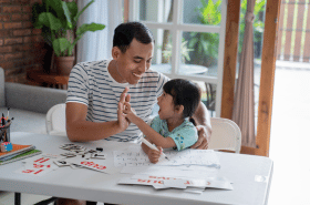 Father and daughter high fiving while setting goals