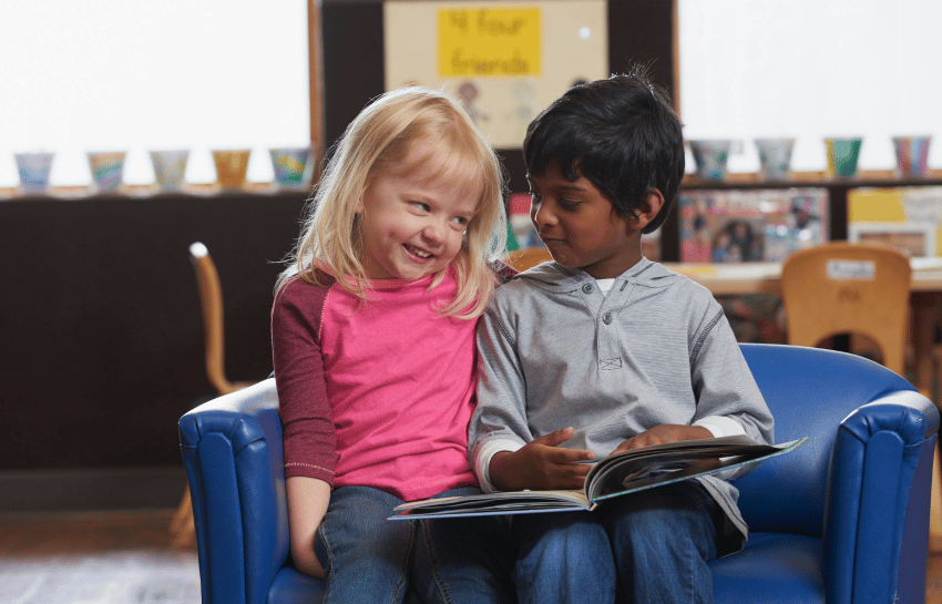 Two young children reading together at daycare