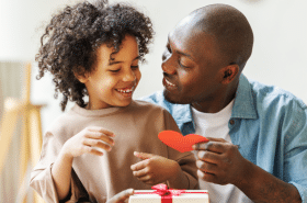 child giving their dad a father's day card and homemade gift