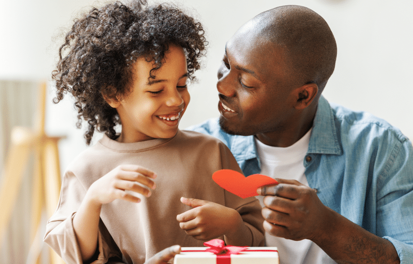 child giving their dad a father's day card and homemade gift