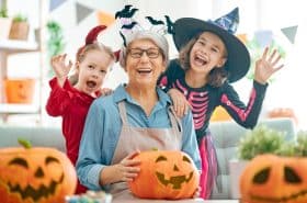 preschool children making you've been booed baskets with their grandmother