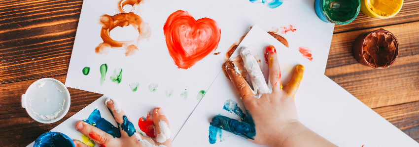 Child practicing their fine motor skills by finger painting