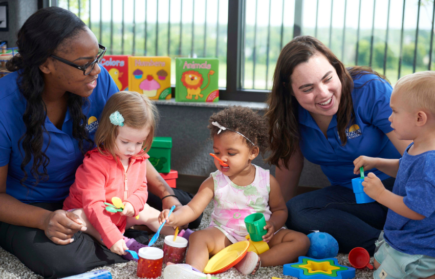 Daycare teachers playing with infants in New Horizon Academy daycare classroom